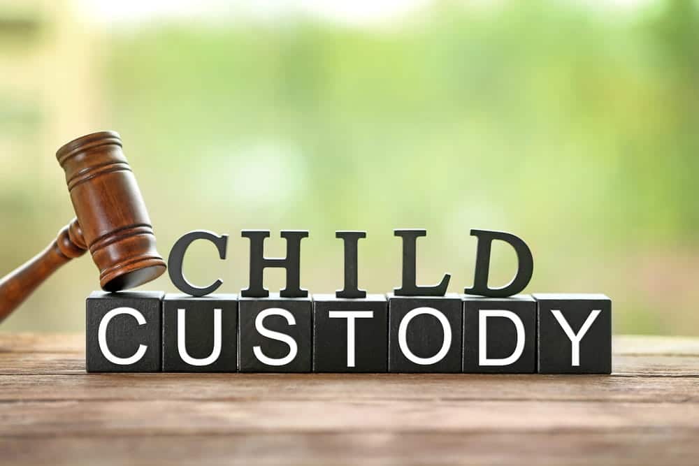 Image is of a gavel beside blocks spelling child custody, concept of a child relocation & interstate custody attorney.