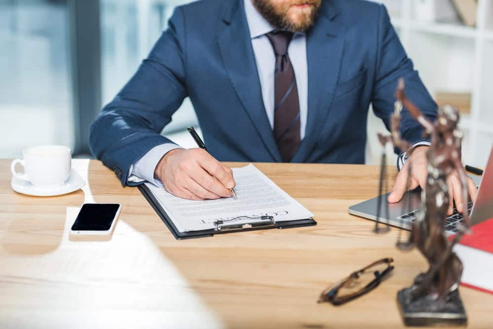 Image is of an attorney reviewing legal documents during a client meeting, concept of child support attorney.