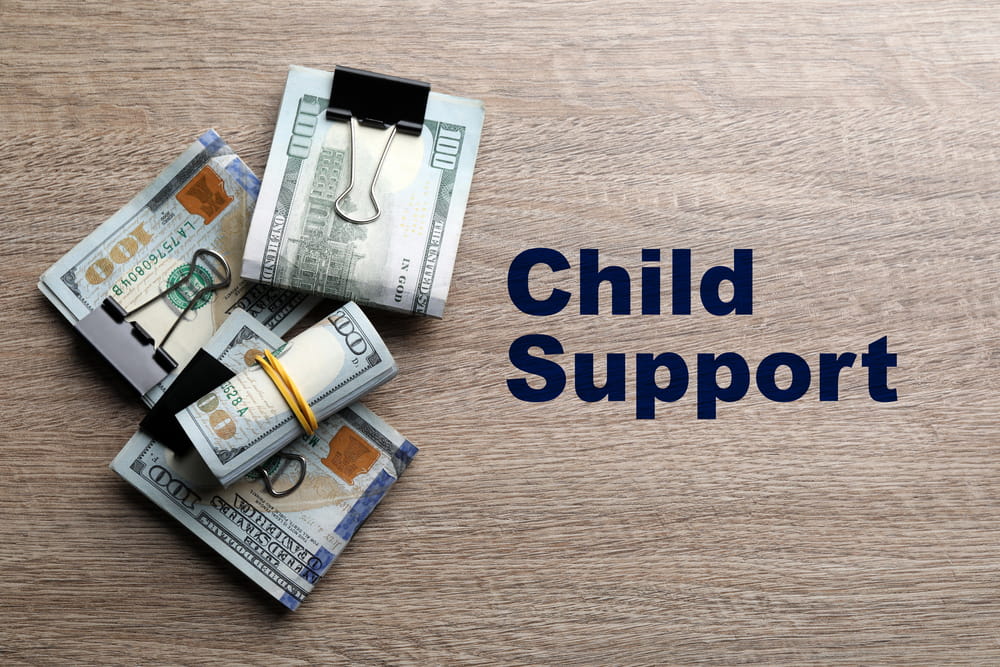 Image is of money beside the words child support, concept of child support attorney.