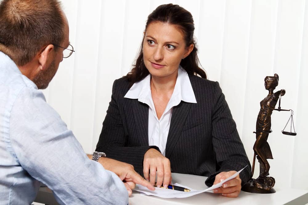Image is of a lawyer discussing legal documents with a client, concept of a collaborative divorce attorney providing guidance throughout the collaborative divorce process.
