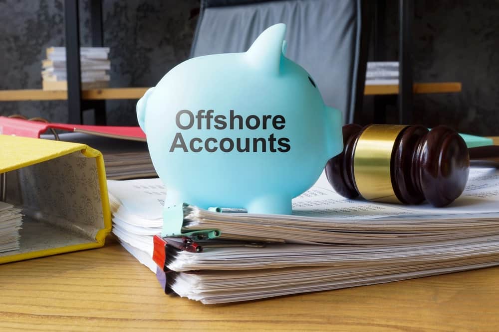 Image is of legal records, a gavel, and an offshore accounts savings bank, concept of a collaborative divorce attorney addressing financial disclosure and asset transparency.