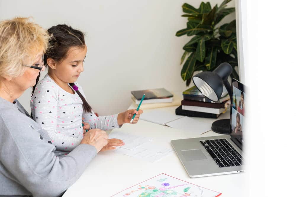 Image is of a grandparent helping a child complete schoolwork at home, concept of a grandparents' rights attorney.