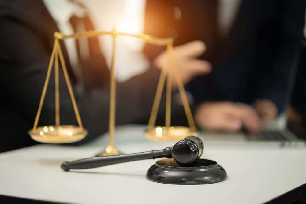 Image is of a judge's gavel and scales of justice on a desk, concept of a high-net-worth divorce attorney resolving equitable distribution matters.