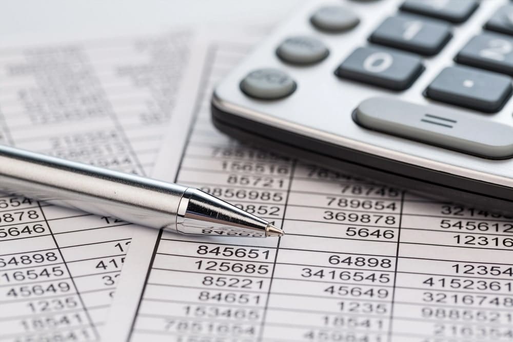 Image is of financial records, a calculator, and a pen, concept of a high-net-worth divorce attorney analyzing complex marital finances and assets.