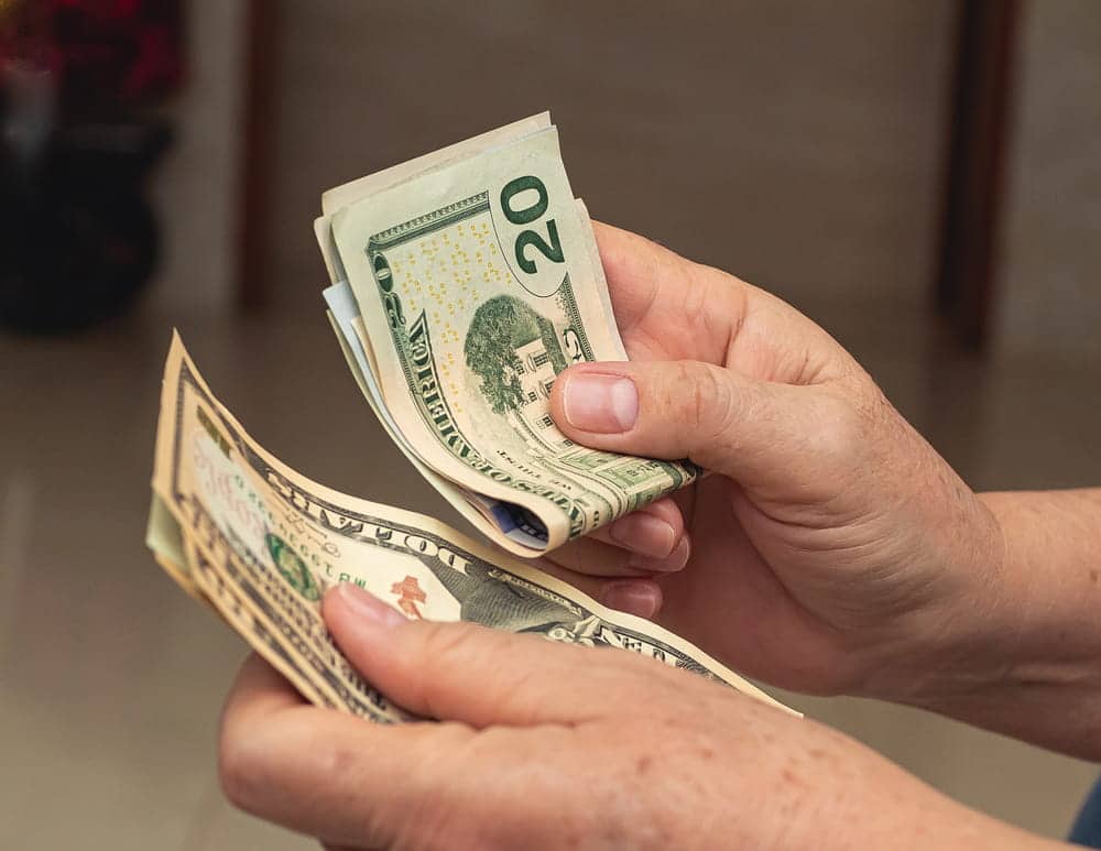 Image is of a person counting cash, concept of a legal separation attorney assisting with financial support, household expenses, and separation-related obligations.