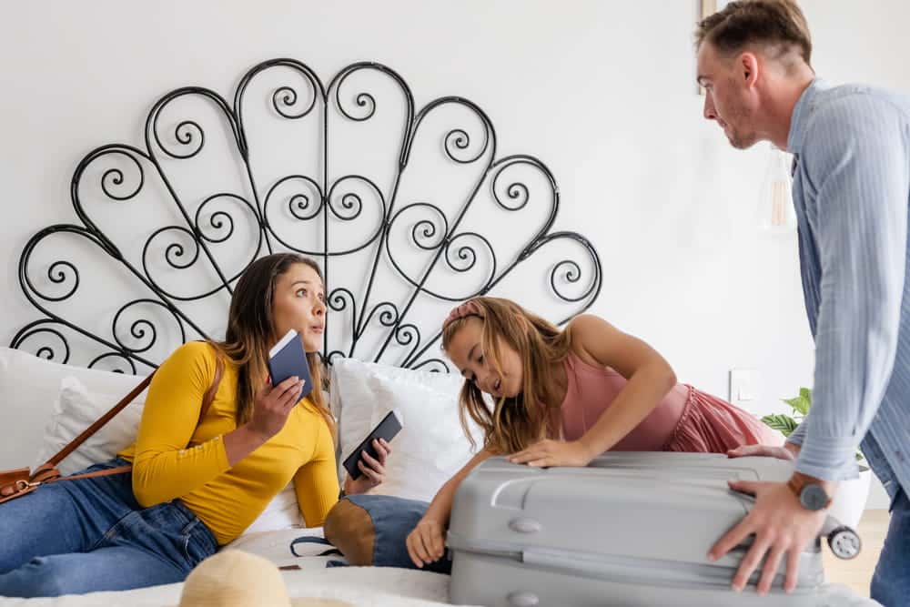 Image is of parents and a child packing belongings during a family separation, concept of a separation agreement addressing parenting and living arrangements.