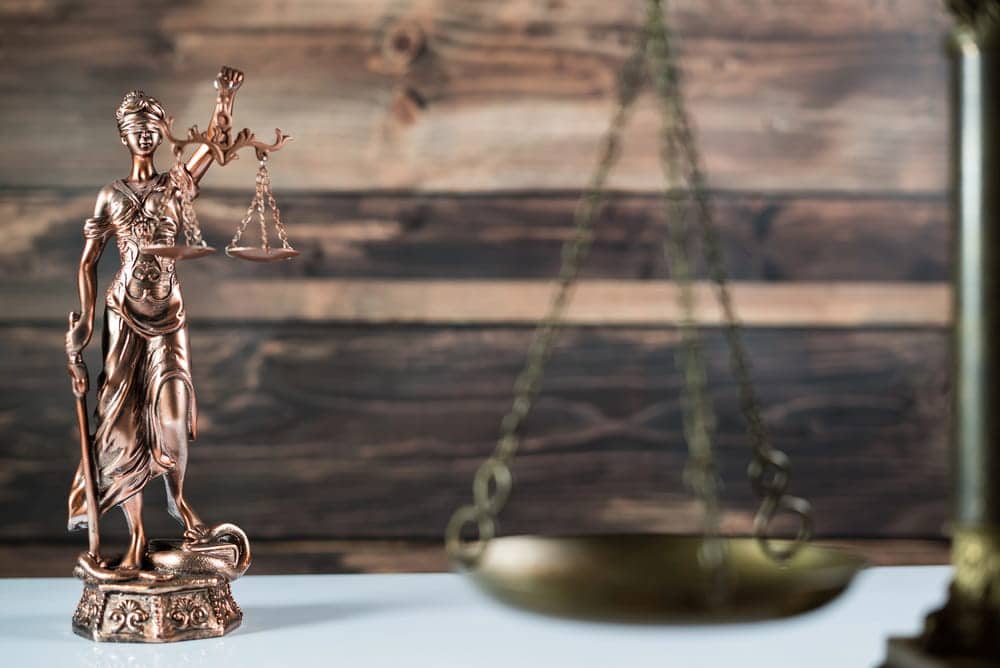 Image is of a Lady Justice statue with scales in the background, concept of divorce mediation services helping couples reach fair and balanced resolutions.