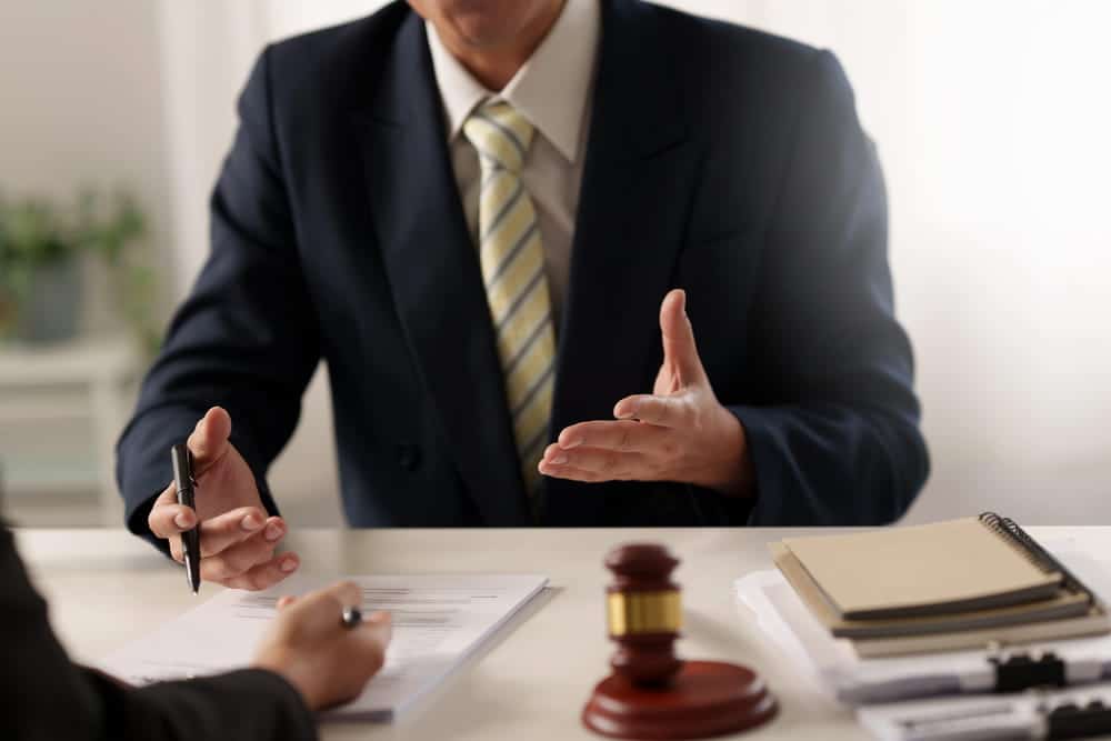 Image is of a lawyer discussing legal options with a client at a desk, concept of an alienation of affection attorney providing legal guidance.