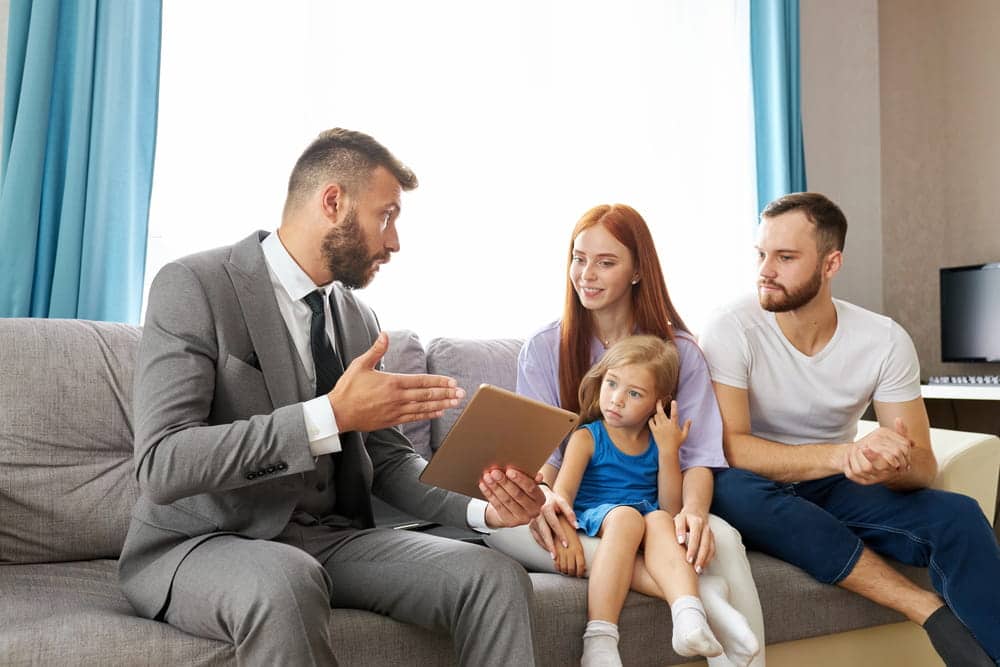Image is of parents meeting with a family law professional while their child listens, concept of parenting coordinator.