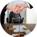 Two people shaking hands across a table during a meeting