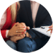 Person in a suit with hands folded across a table