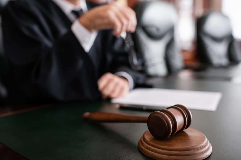 Image is of a judge holding a gavel at the bench, concept of a decision at a child custody hearing in Charlotte.